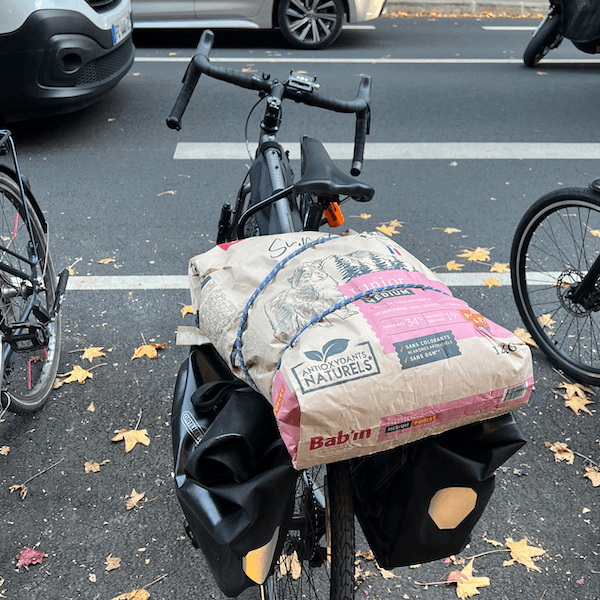 Un vélo sur lequel est posé un très gros sac de croquette pour chien